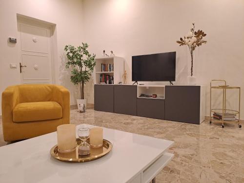 een woonkamer met een tv en een bank en een tafel bij La Corticella in Lucca