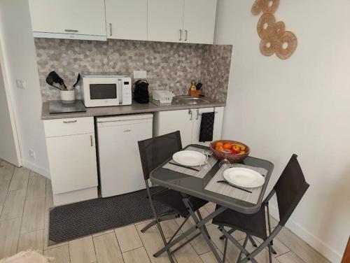 a kitchen with a table with chairs and a microwave at Cocoon urbain : Aux portes des JO et de Disney in Vaires-sur-Marne