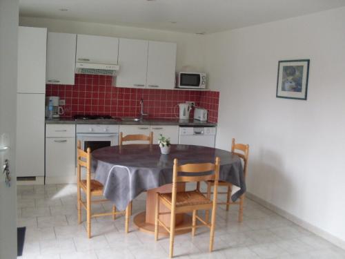 a kitchen with a table and chairs in a room at Gîte de Fourneaux in Pont-d'Ouilly