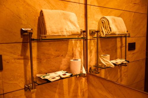 a bathroom with two towel racks and towels at NESTLAYROOMS RAMNAD in Rāmanāthapuram