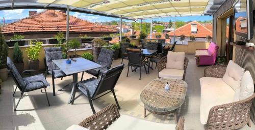 a patio with tables and chairs on a balcony at Guest House Ćiro in Sarajevo