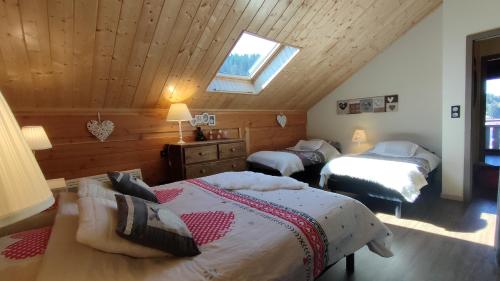 a bedroom with two beds and a skylight at Chalet 360 l Essenti Aile, Gerardmer La Mauselaine in Gérardmer