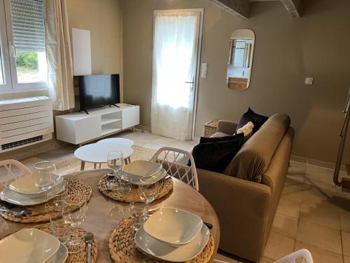 ein Wohnzimmer mit einem Sofa und einem Tisch in der Unterkunft Appartements St. Pancrace in Corte