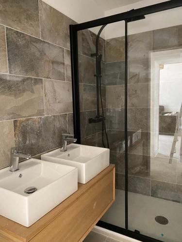 une salle de bain avec deux lavabos et une douche dans l'établissement Gîtes chez Marceau, à Rasteau