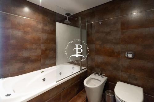 La salle de bains est pourvue d'une baignoire, de toilettes et d'un lavabo. dans l'établissement Tríplex Moderno con parrilla y jardín- Baires !, à Buenos Aires