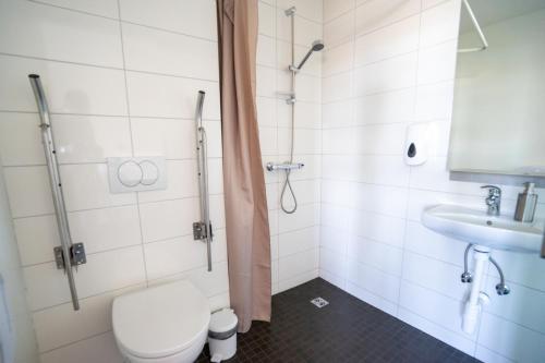 a bathroom with a toilet and a sink at Skulagardur Country Hotel in Garður