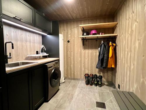 a small kitchen with a sink and a washing machine at Høgerinden Lodge in Sogndal