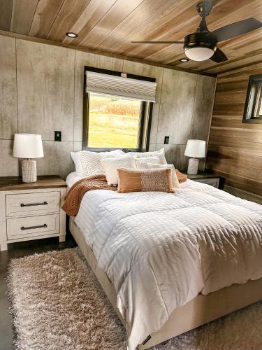 1 dormitorio con 1 cama grande y ventilador de techo en Modern Tiny Home, 