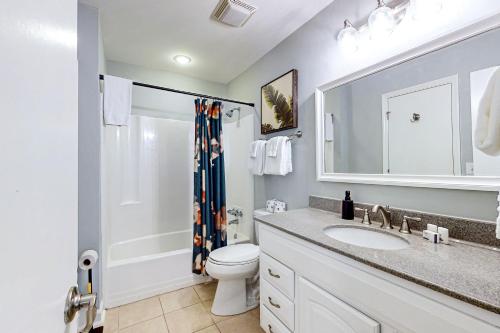 a bathroom with a sink and a toilet and a shower at The Palm Frond Stay in Isle of Palms