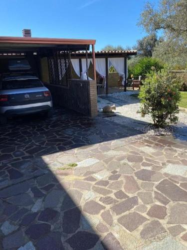 a car parked next to a house with a stone driveway at Panorama Penthouse con giardino privato in Santadi