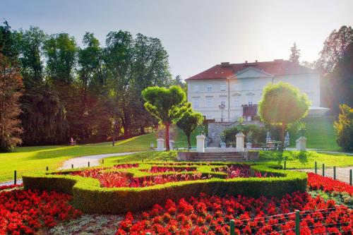 een tuin met rode bloemen voor een gebouw bij Apartma Tea in Ljubljana