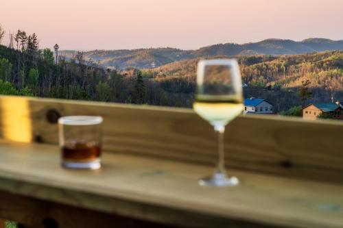 a glass of wine sitting on a table with a view at Mountainscape - Brand New Cabin w Views - HotTub - FireTable - PS5 - PoolTable - 3 Pools in Gatlinburg