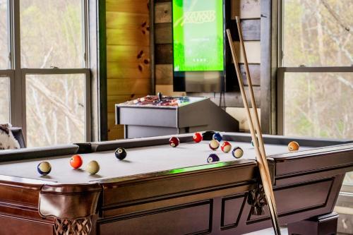 a room with a pool table and a tv at Mountainscape - Brand New Cabin w Views - HotTub - FireTable - PS5 - PoolTable - 3 Pools in Gatlinburg