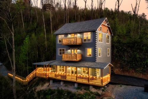 a large house with a deck on top of it at Mountainscape - Brand New Cabin w Views - HotTub - FireTable - PS5 - PoolTable - 3 Pools in Gatlinburg