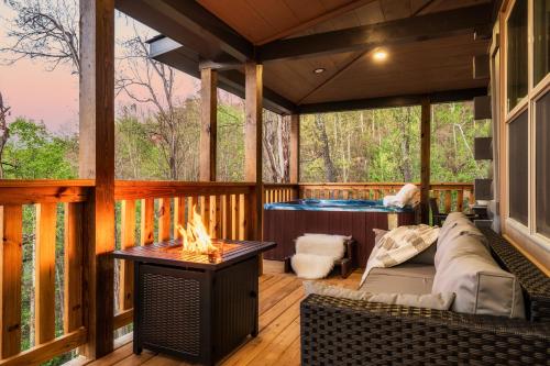 a screened in porch with a couch and a fireplace at Mountainscape - Brand New Cabin w Views - HotTub - FireTable - PS5 - PoolTable - 3 Pools in Gatlinburg