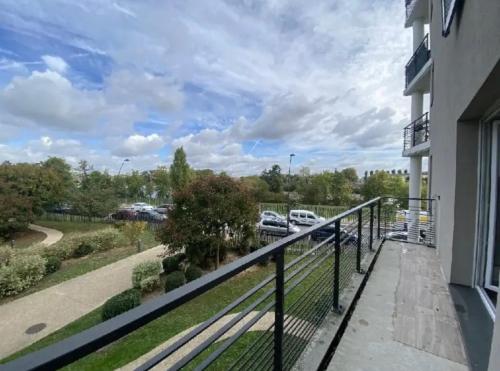 un balcon avec vue sur un parking dans l'établissement Super T2 meublé en bord de seine, à Villeneuve-le-Roi