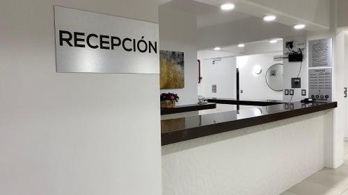 a white bathroom with a counter with a reception sign at Hotel Santa Fe in Tuxtla Gutiérrez
