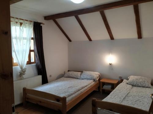 een slaapkamer met 2 bedden en een raam bij Guesthouse Nemanja in Šljivovica