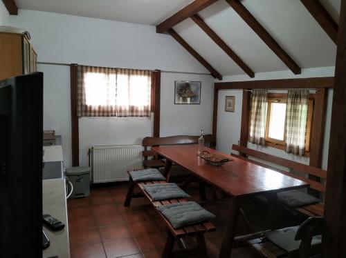 ein Esszimmer mit einem Holztisch und Stühlen in der Unterkunft Guesthouse Nemanja in Šljivovica