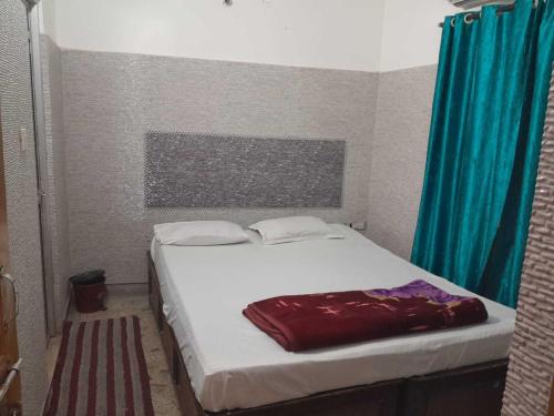 um quarto com uma cama branca e uma cortina azul em SPOT ON Hotel Sagar em Deoghar