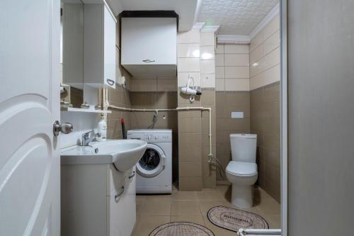 y baño con lavamanos y lavadora. en Benjamin Rezidance, en Estambul