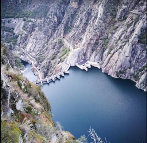 an aerial view of a bridge over a mountain lake at Cabañas Miraduero in Aldeadávila de la Ribera