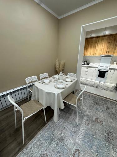 une salle à manger avec une table et des chaises ainsi qu'une cuisine dans l'établissement ЖК Керемет Ашимова 21А, à Fëdorovka