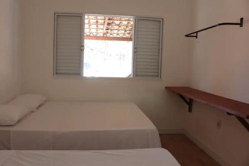 a bedroom with two beds and a window at Casa na fazenda inteira ou quartos individuais no Hostel Recanto da Felicidade Paraopeba in Paraopeba