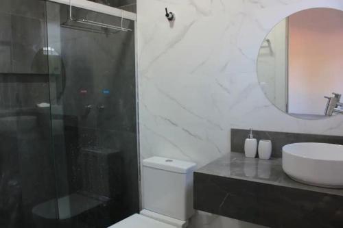 La salle de bains est pourvue de toilettes, d'un lavabo et d'une douche. dans l'établissement Chacara Alto Padrão Recanto Felicidade Paraopeba, à Paraopeba
