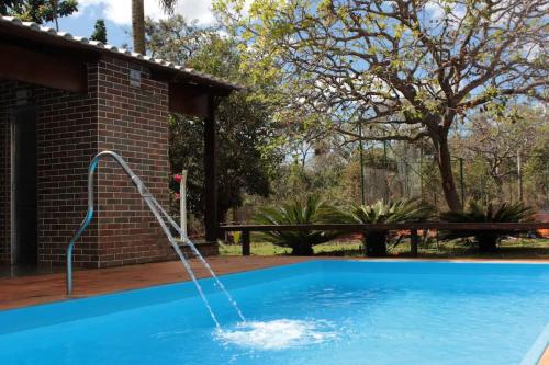 a swimming pool with a water fountain at Casa na fazenda inteira ou quartos individuais no Hostel Recanto da Felicidade Paraopeba in Paraopeba