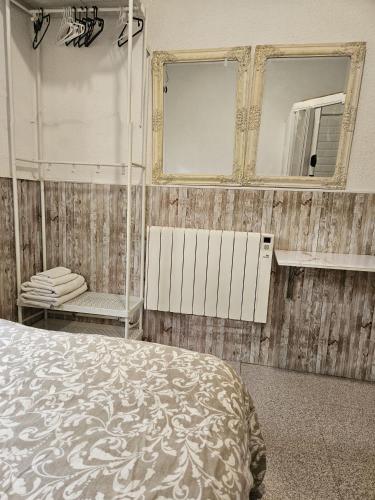 a bedroom with a bed and mirrors on the wall at Habitacion en casa de familia "ValenciaBonita" in Valencia