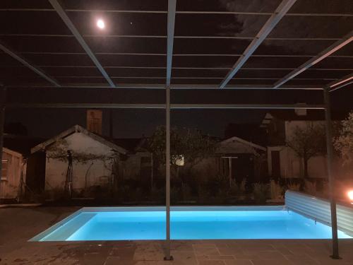 a swimming pool at night with the moon overhead at Chai Nous in Rion-des-Landes