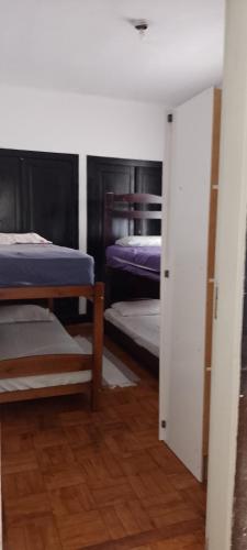 a room with two bunk beds and a door to a bedroom at Rafa's hostel in Sao Paulo