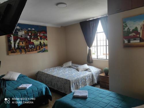 a bedroom with two beds and a window at Hamuy's Lodge in Ica