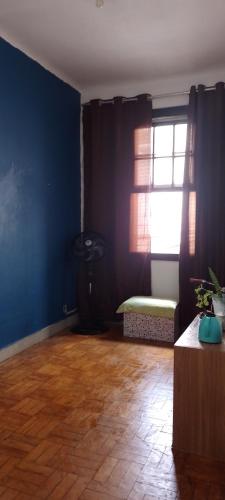 a living room with a blue wall and a window at Rafa's hostel in Sao Paulo
