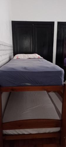 a bed with a wooden frame and a blue mattress at Rafa's hostel in Sao Paulo
