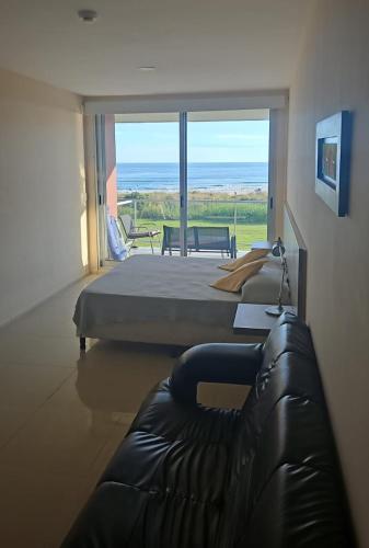 a bedroom with a bed and a couch and a view at Audencia del Mar in La Paloma