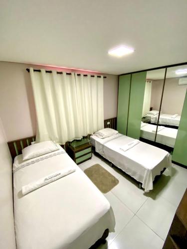a hotel room with two beds and a mirror at Residencial renaissance in Boa Vista
