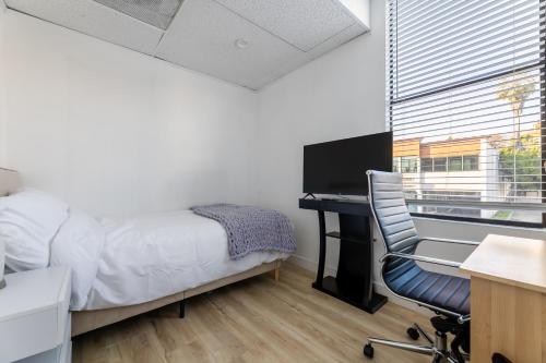a bedroom with a desk and a bed and a chair at Booking Urban Oasis room in central Pasadena in Pasadena