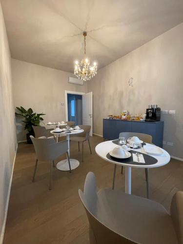 a dining room with two white tables and chairs at CorteCairoli in Gropello Cairoli