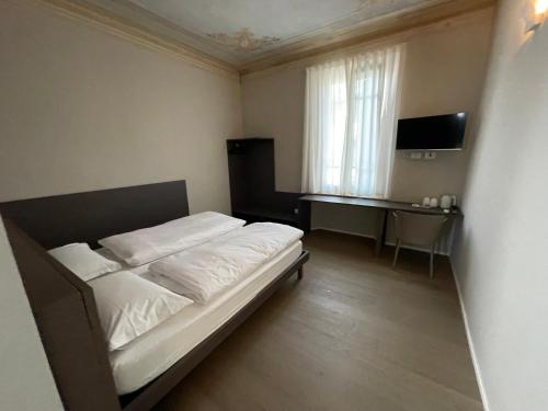 Habitación pequeña con cama y escritorio. en CorteCairoli, en Gropello Cairoli