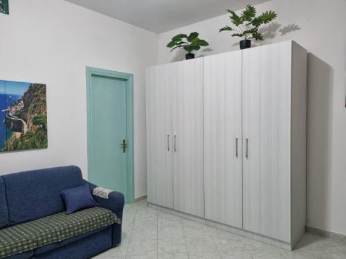 um grande armário branco numa sala de estar com um sofá azul em Un sogno chiamato Ravello em Ravello