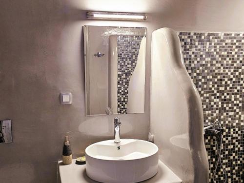 a bathroom with a white sink and a mirror at Aqua & Terra Traditional Cave Houses in Oia