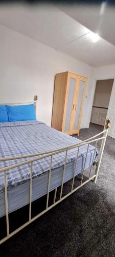 um quarto com uma cama com uma colcha azul e armários de madeira em MC Suites em Old Walker