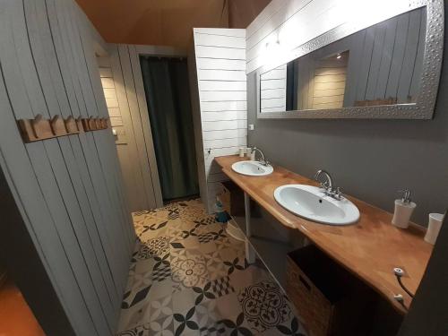 une salle de bain avec deux lavabos et un miroir dans l'établissement Lodge Nature à Vigeois, à Vigeois