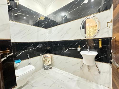 a black and white bathroom with a sink and a toilet at Hotel EMBASSY 250 Meter From Golden Temple in Amritsar