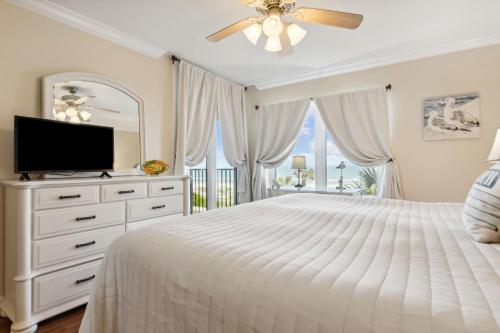 a white bedroom with a bed and a television at 1639 Sea Dunes in Amelia Island