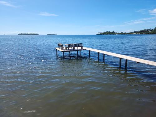a bench sitting on a dock in the water at Taina - Terrasse - Bord de mer - in Opoa