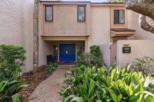 a house with a blue door and plants at 2009 Beach Wood in Amelia Island