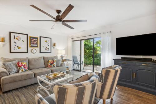 a living room with a couch and a flat screen tv at 2009 Beach Wood in Amelia Island